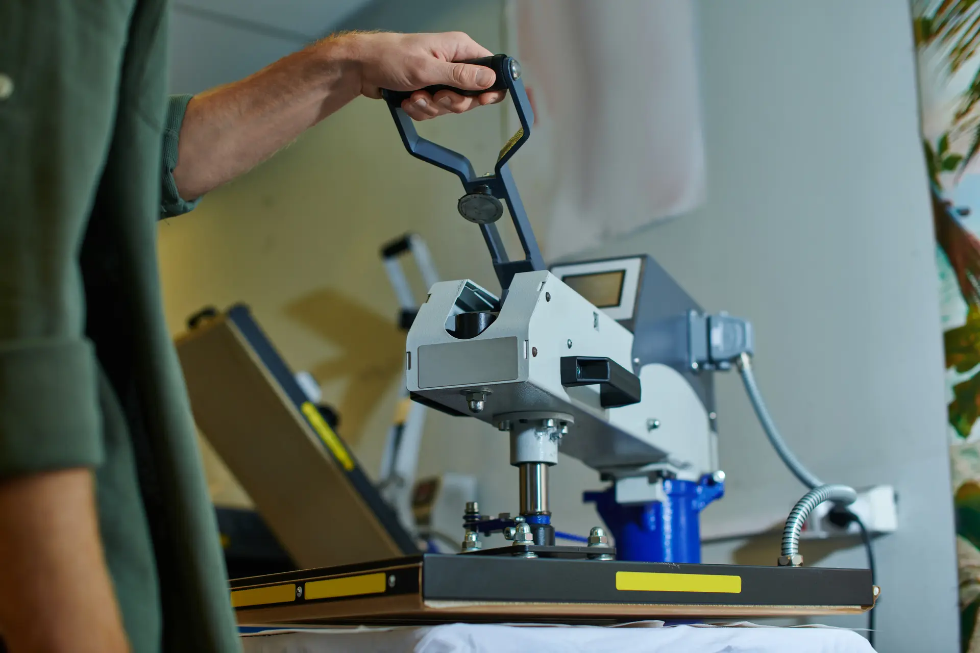 A Splor employee using a heat press machine